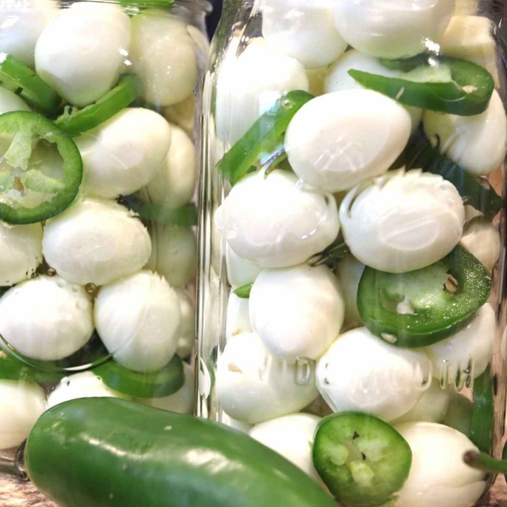 glass mason jars of quail eggs and jalapenos