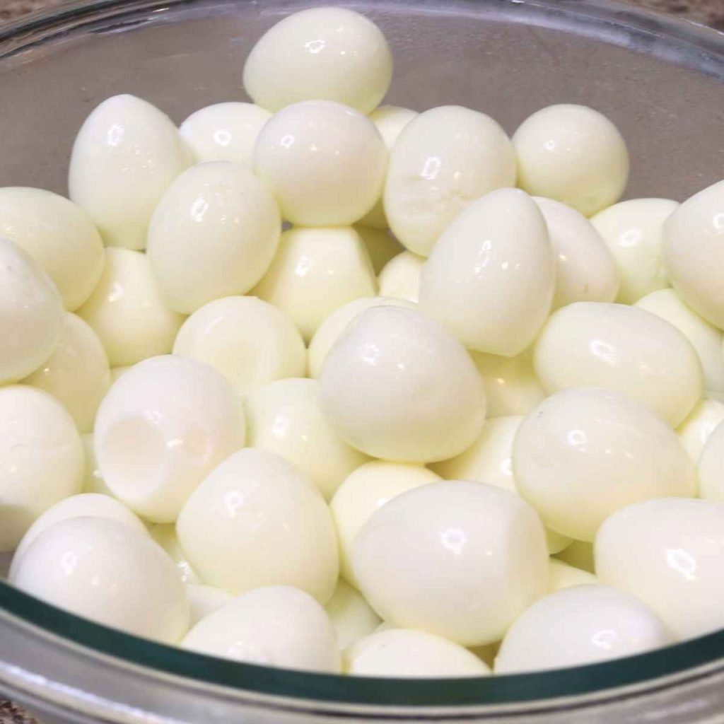 glass bowl of peeled small eggs