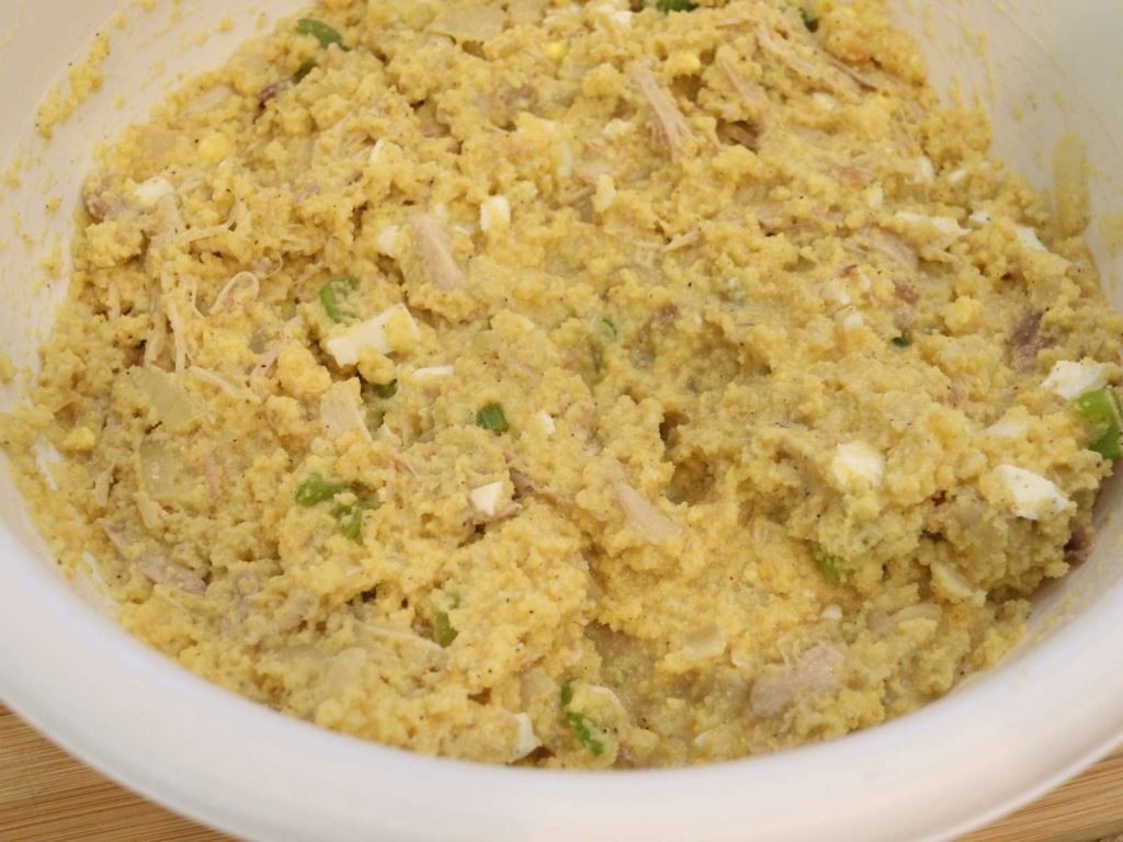 ALL INGREDIENTS FOR CORNBREAD DRESSING MIXED TOGETHER WITH CHICKEN BROTH IN A LARGE BOWL