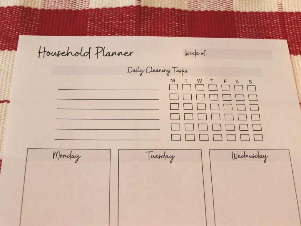 printable household planner sitting on red and white checkered tablecloth