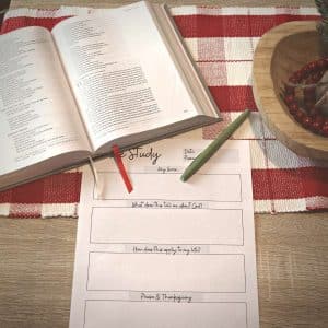 Open Bible sitting on table with Bible Study worksheet printable