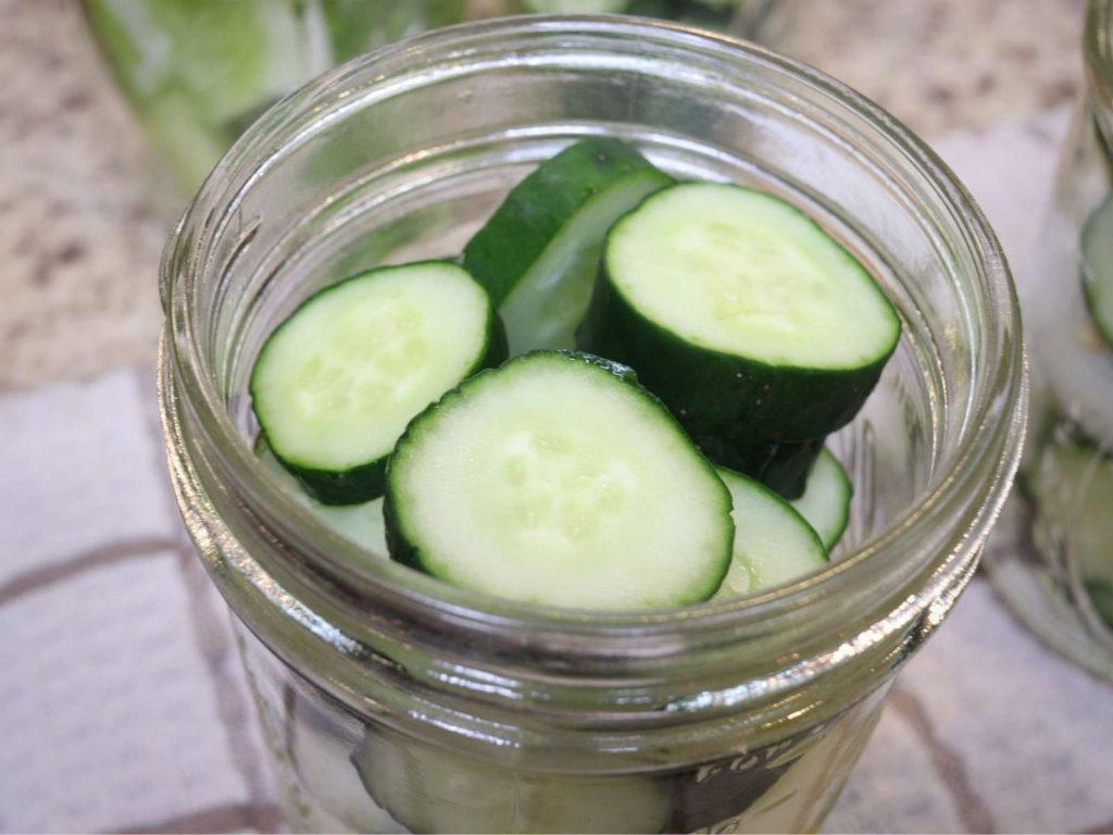 slices of cucumber in glass mason jar