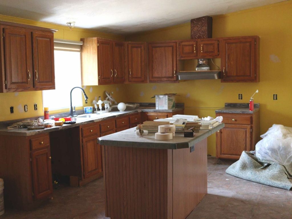 double wide kitchen area with brown cabinets, green counters, and yellow walls