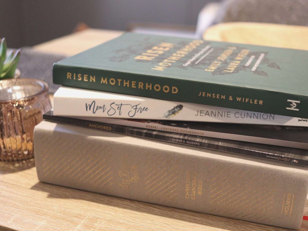 Bible and Christian motherhood books stacked on table
