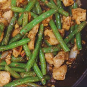 green beans with cashew chicken in black cast iron skillet