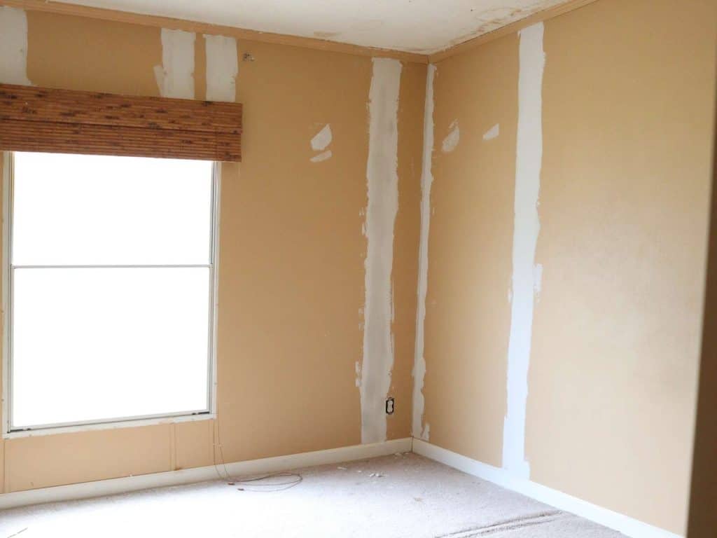 old mobile home bedroom with strips on walls in between sheetrock