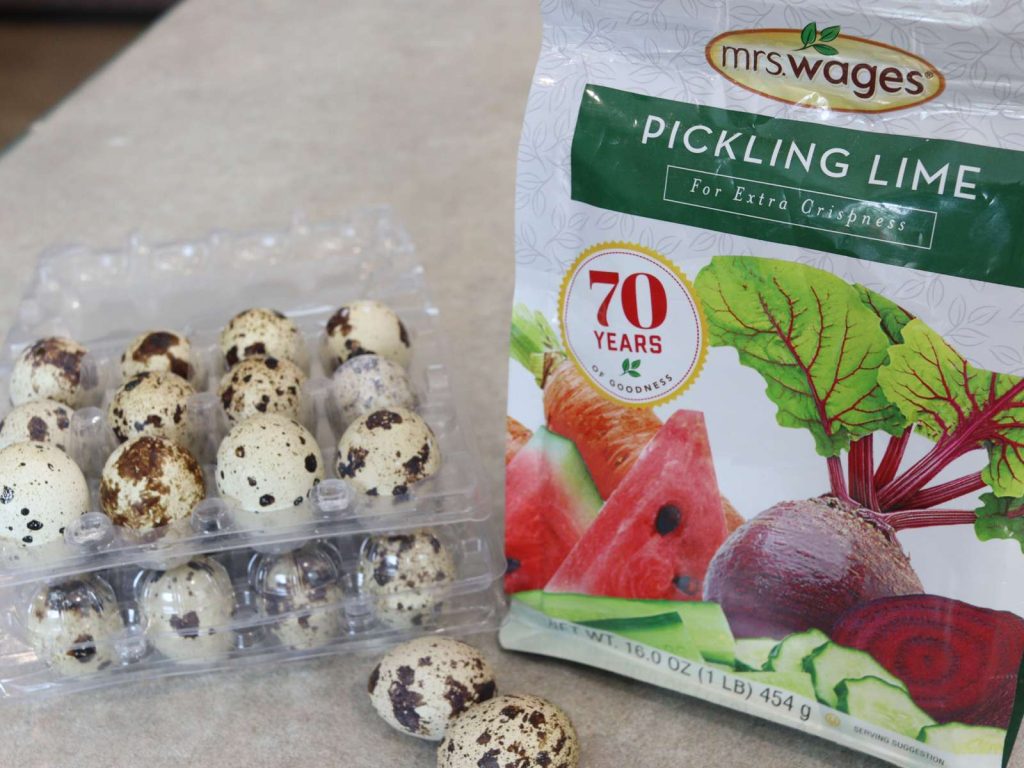 quail eggs in plastic carton and bag of mrs wages pickling lime sitting on counter