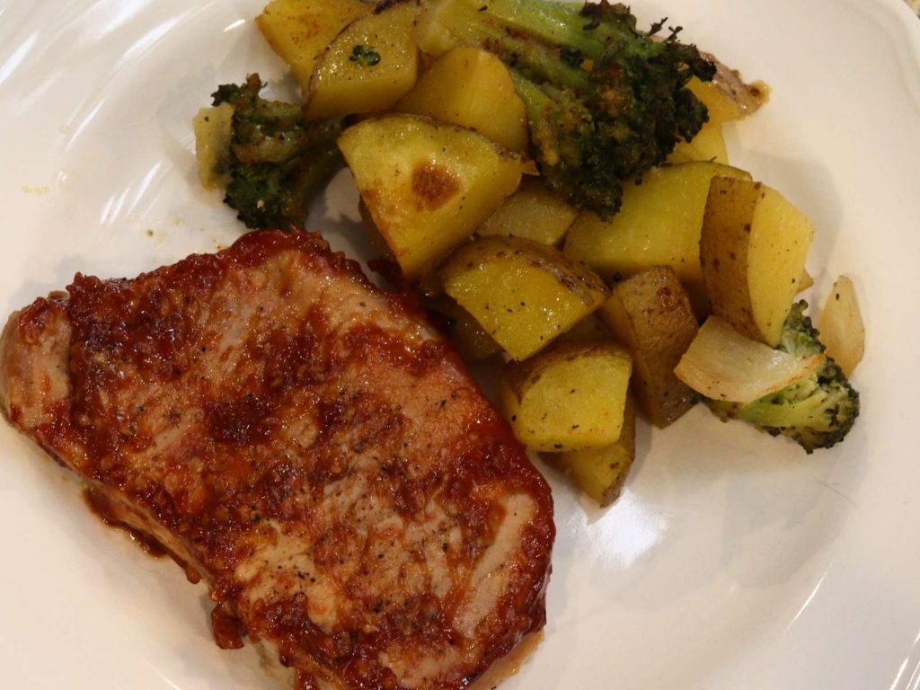 roasted pork chops, potatoes, and broccoli on white plate