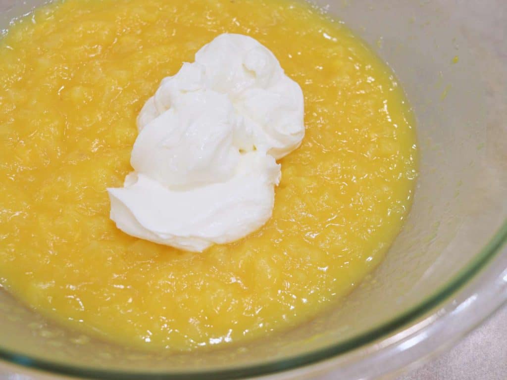 yellow crushed pineapple in glass bowl with sour cream