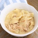 homemade chicken and dumplings in a white bowl