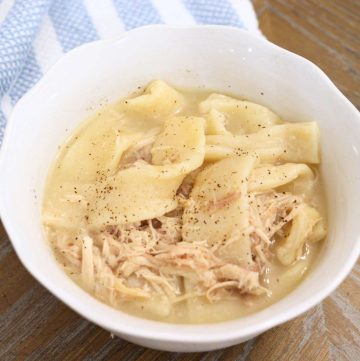 homemade chicken and dumplings in a white bowl