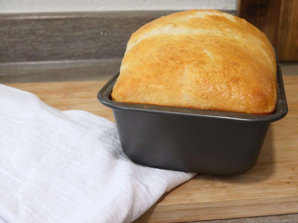 loaf of homemade dairy free bread in a bread pan 