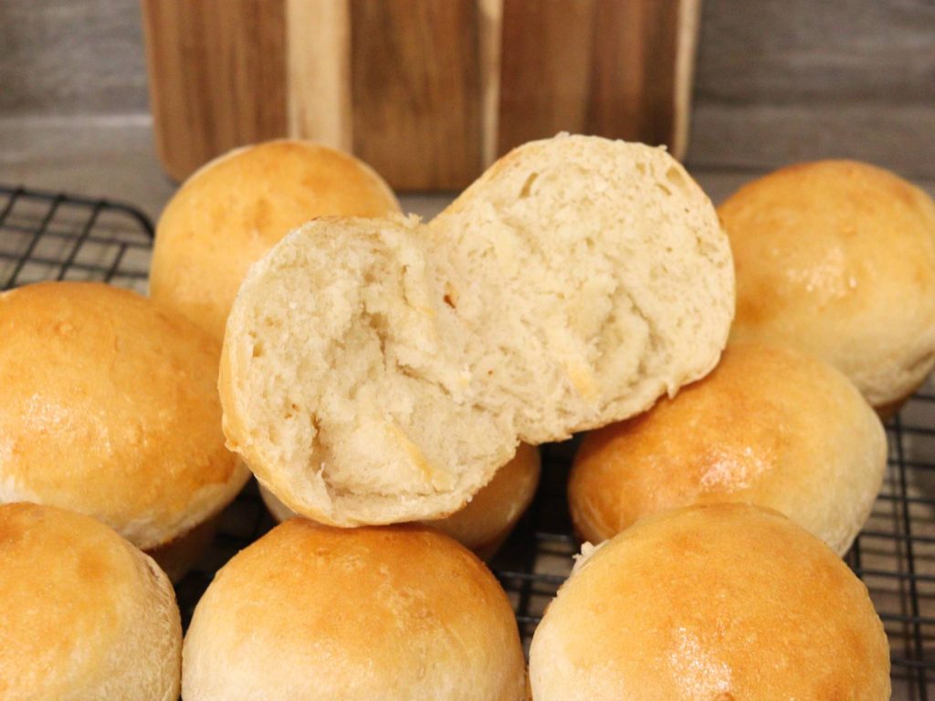 golden brown homemade dinner rolls on cooling rack