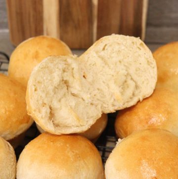 golden brown dinner rolls with one split in half