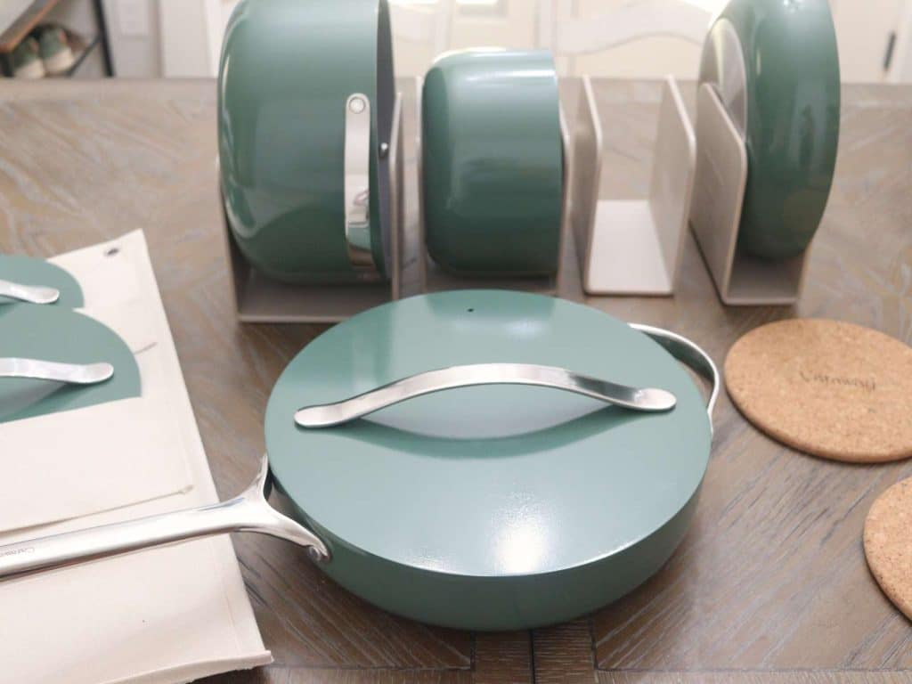 green enamel cookware set sitting on kitchen table