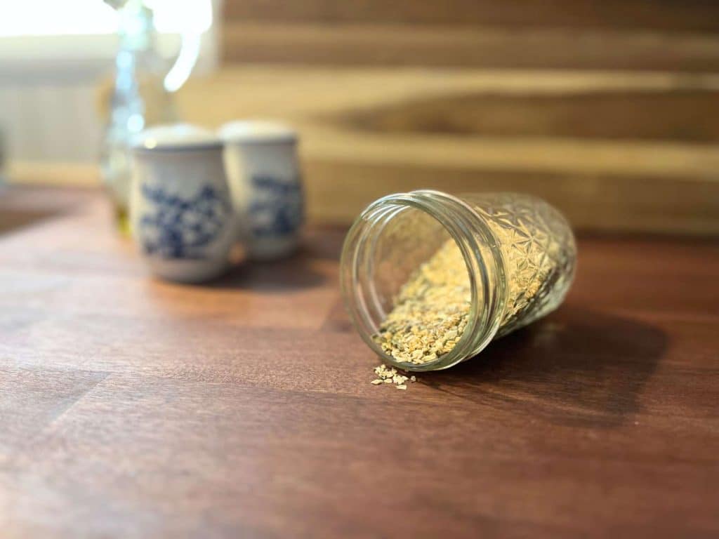 seasoning blend in small glass jar on wooden butcher block countertop