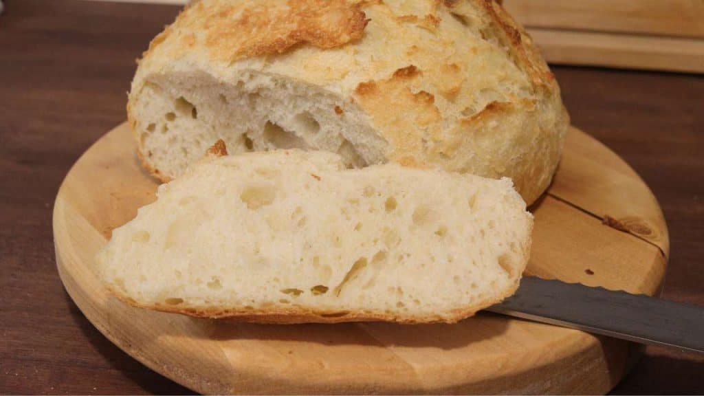 round loaf of homemade bread sitting on wooden cutting board