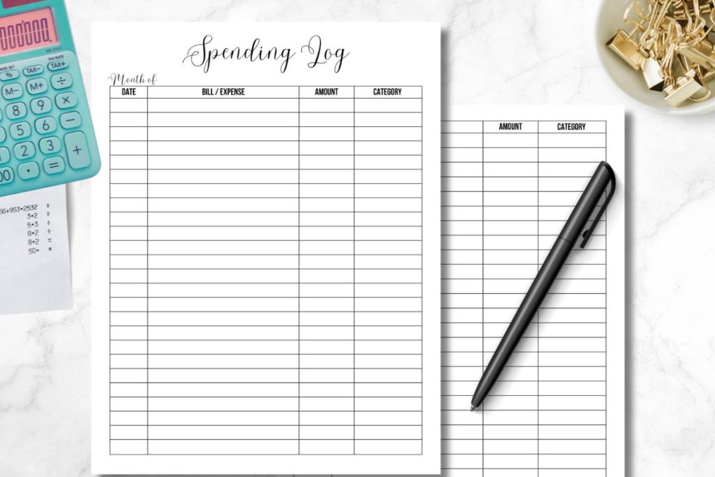 spending log planner pages on white marble desk with office supplies