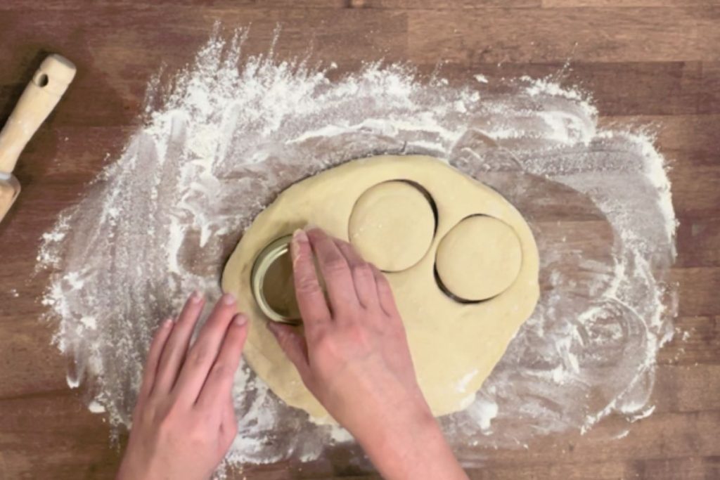 dough for sliders being cut on wooden work surface