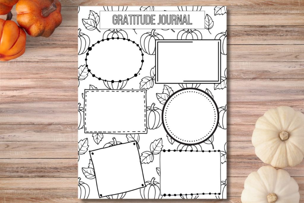 gratitude journal page with fall background on wooden counter with pumpkins