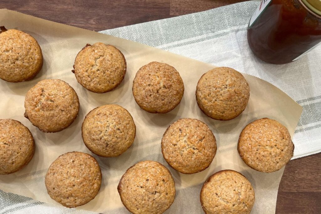 apple butter muffins sitting on parchment paper on green and white towel