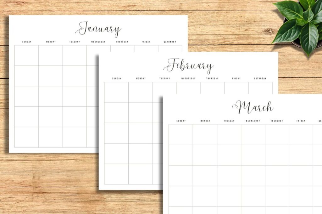 undated monthly calendar pages sitting on wooden desk