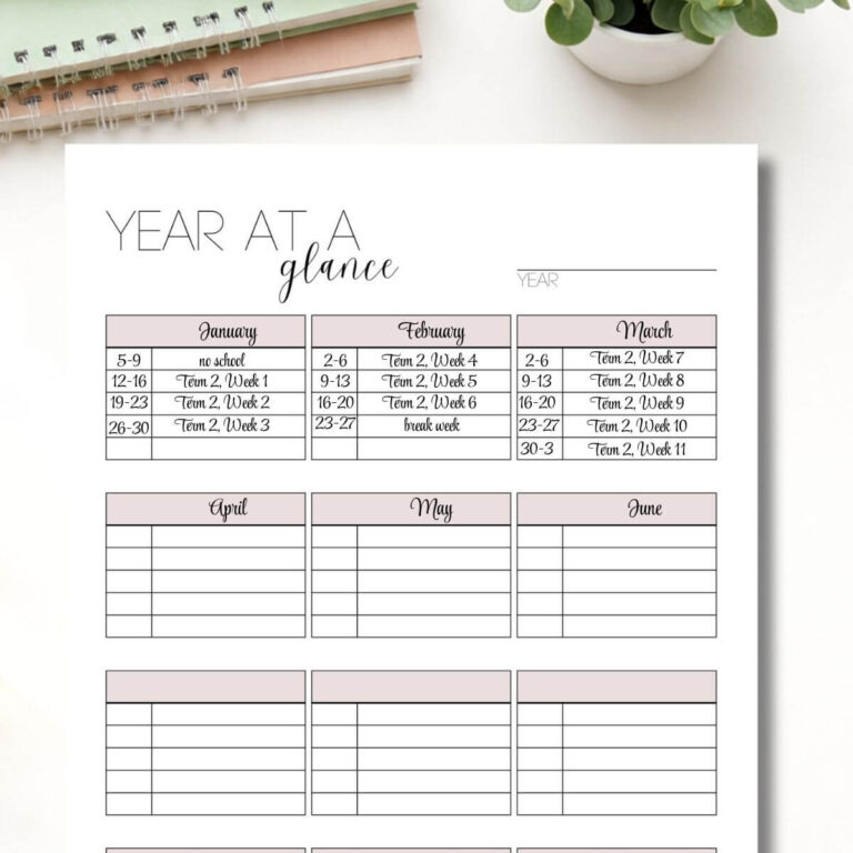 year at a glance planning page on white table with a small plant and notebooks